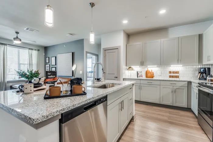 Modern kitchen and cozy living space with sleek design, featuring an elegant granite countertop and stylish lighting accents.
