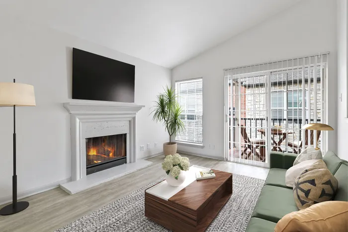 Living room, with wall mounted tv, fireplace, coffee table, lamp,and rug.