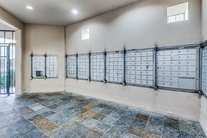 Chic apartment mailbox area with elegant stone tile flooring and a sleek design, offering convenience and style.