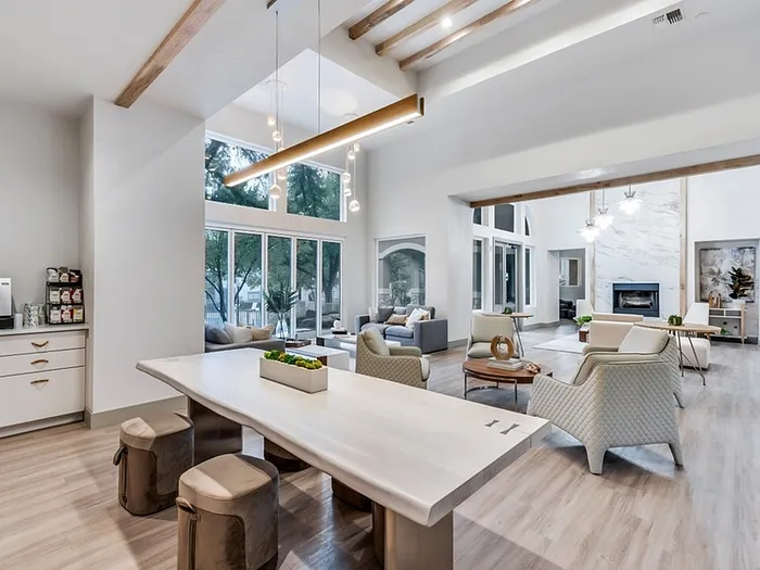 Elegant open-concept living area with modern furnishings, cozy fireplace, and abundant natural light streaming through large windows.