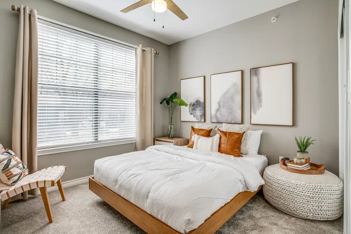 Beautifully designed bedroom with cozy bed, stylish pillows, and elegant decor, featuring large window with ample natural light.