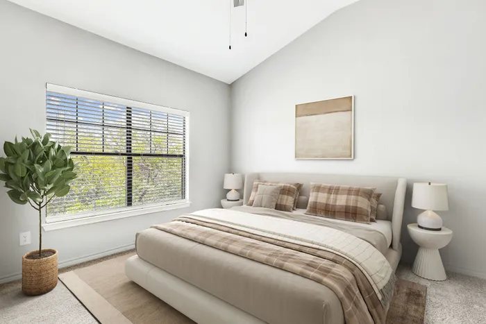 Bright and inviting bedroom with large window, stylish decor, and cozy bedding, perfect for relaxation.