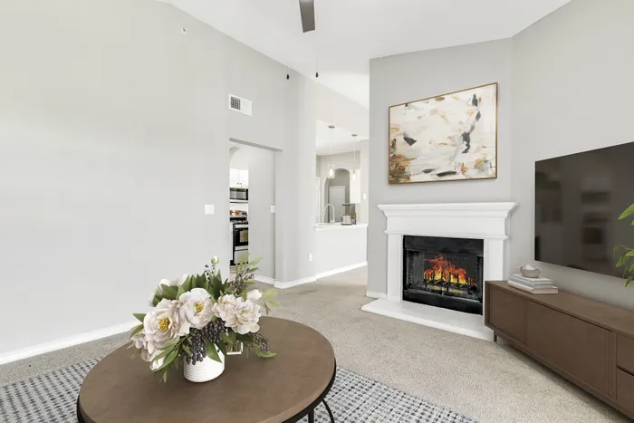 Chic living room featuring a cozy fireplace, elegant artwork, and modern furnishings in an open, inviting space.