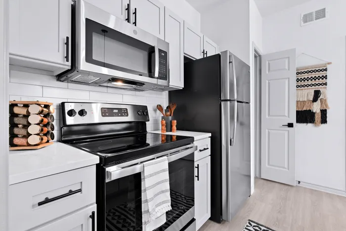 Modern kitchen with sleek stainless steel appliances, elegant white cabinetry, and stylish decor, perfect for culinary enthusiasts.