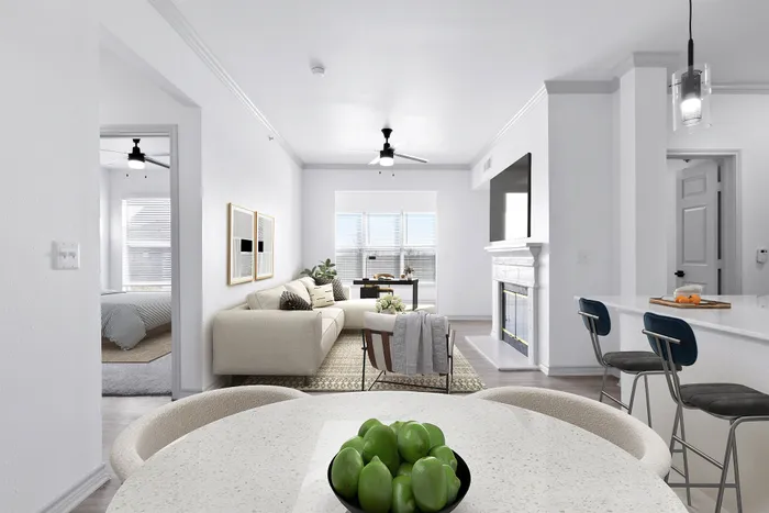 Bright and modern living area with cozy beige sofa, sleek kitchen island, and inviting fireplace, perfect for relaxing and entertaining.