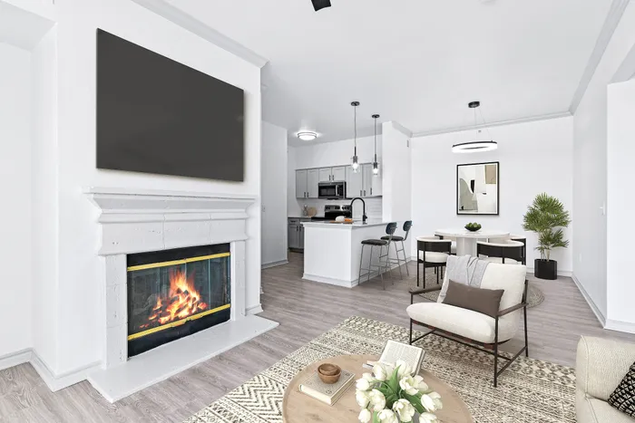 Elegant open-concept living room showcasing a cozy fireplace, modern kitchen with island seating, and inviting dining area, perfect for entertaining.