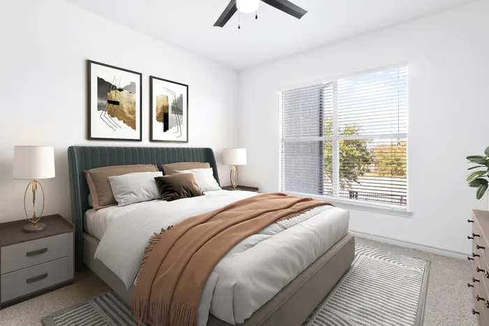 Elegant bedroom with a plush bed adorned with stylish pillows and a warm throw, complemented by modern art and large windows allowing natural light.