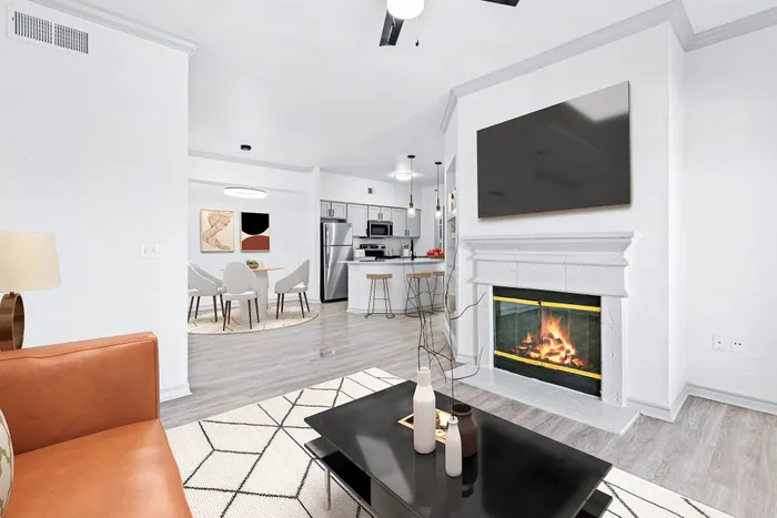 Modern open-concept living room with cozy fireplace, sleek kitchen, and stylish dining area, ideal for entertaining.