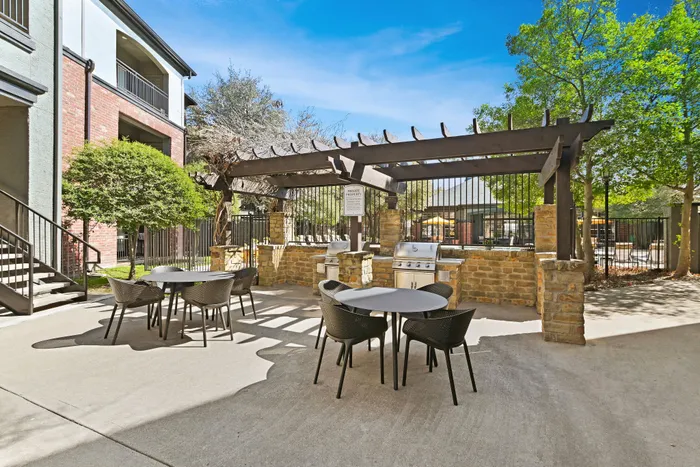 Brick grill with cabana and two sets of table and chairs