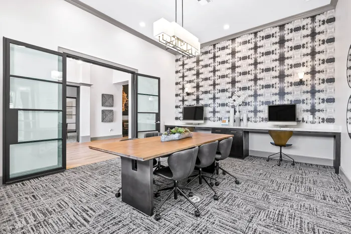 Resident business center with large rectangular table and chairs.
