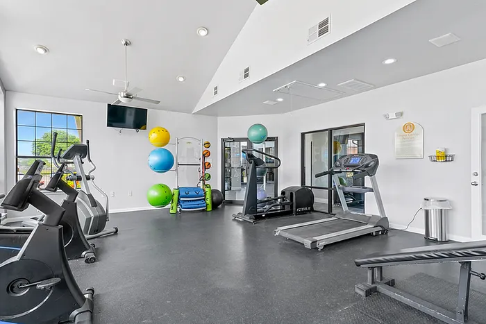 Fitness center with cardio machines, expansive weindows, and ceiling fans