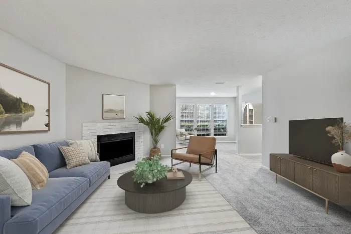 Spacious apartment living room with plush carpeting, modern furnishings, decorative fireplace, large windows, and open-concept layout with abundant natural light.