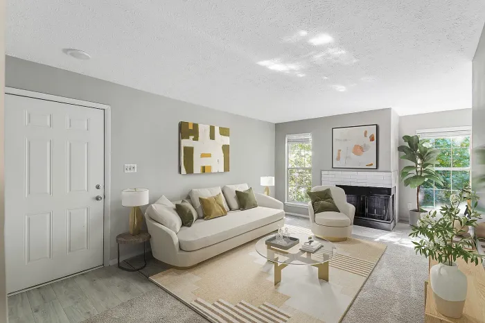 Bright apartment living room with modern furnishings, decorative fireplace, large windows, plush carpeting, and contemporary décor with natural light.
