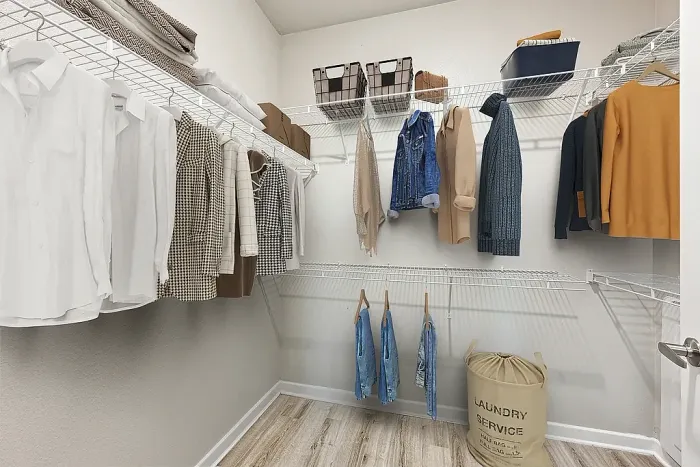 Spacious walk-in closet with organized shelving and stylish wardrobe, perfect for fashion enthusiasts.