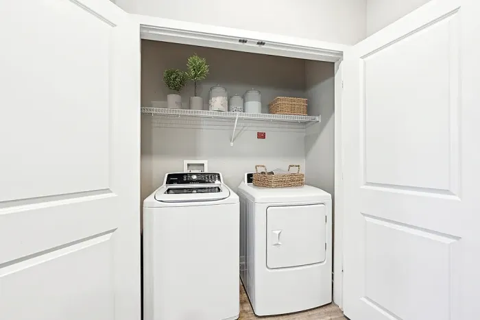 Sleek laundry nook with modern washer and dryer, featuring organized shelving and elegant decor.