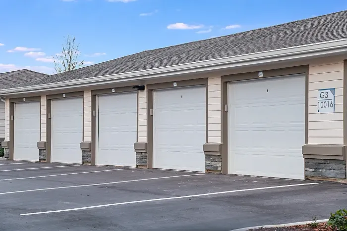 Row of detached garage units with individual doors and designated parking spaces.