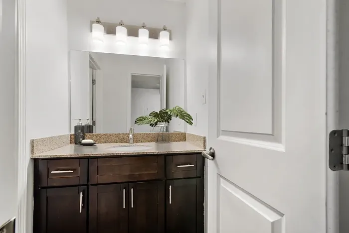 Elegant bathroom featuring modern vanity with dark wood cabinets, granite countertop, and ambient lighting.