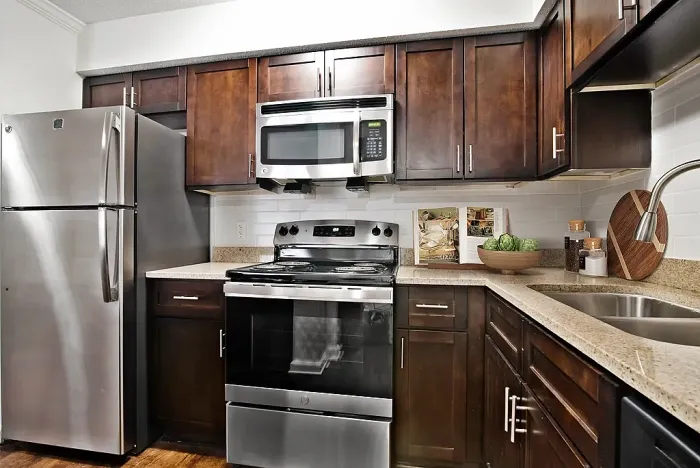 Modern kitchen with sleek stainless steel appliances, dark wood cabinets, and granite countertops providing a sophisticated touch.