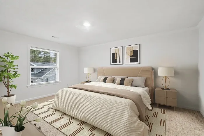 Bright and elegant bedroom featuring a plush bed, stylish decor, and large window with garden views.