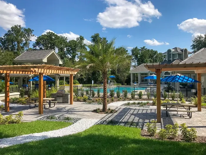 Outdoor grilling and picnic area with pergolas, seating, and pool.