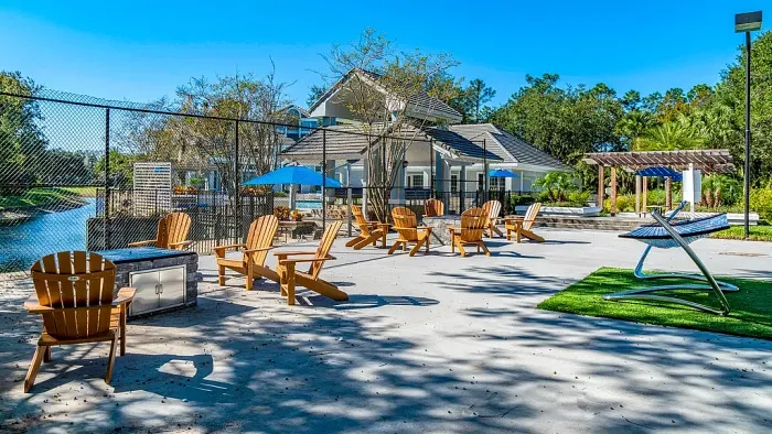 Outdoor lounge with fire pit, Adirondack chairs, hammocks, and open seating area
