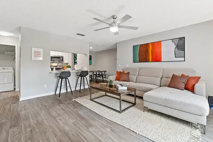 Open-concept living space with kitchen, breakfast bar seating, and hardwood-style flooring.