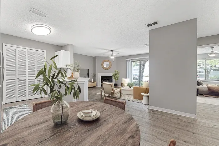 pen-concept dining and living space with fireplace, natural light, and hardwood-style flooring.