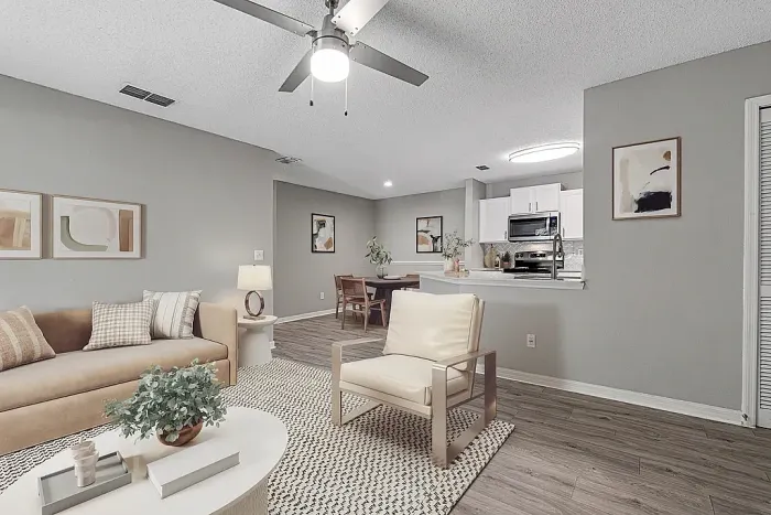 pen-concept living and dining area with breakfast bar, white kitchen, and wood-style flooring.