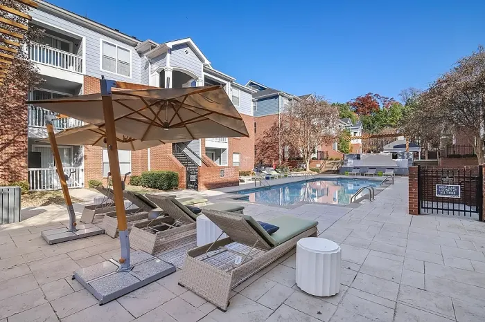 Beautiful resort-style swimming pool with premium lounge seating, shaded cabanas, and relaxing outdoor amenities set within a modern apartment community.
