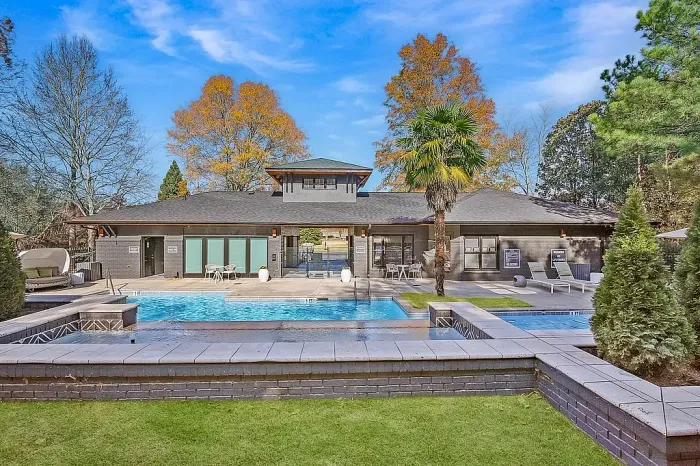 Modern resort-style pool and clubhouse area featuring luxurious lounge spaces, tropical landscaping, and beautifully designed outdoor amenities perfect for relaxation and entertaining.