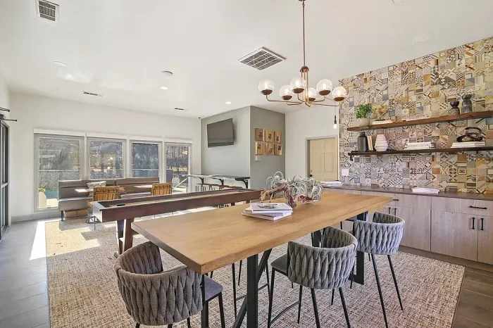Stylish resident clubhouse featuring shuffleboard, lounge seating, and entertainment space.