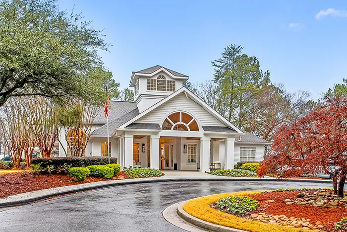 Charming leasing office entrance with manicured landscaping and elegant architectural design, perfect for a welcoming home.