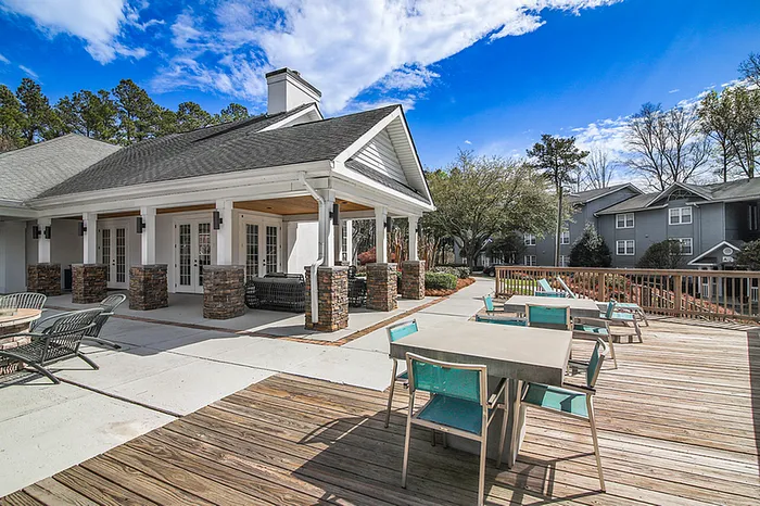 Inviting outdoor patio with stylish seating, perfect for relaxation and social gatherings, surrounded by lush greenery and elegant architecture.