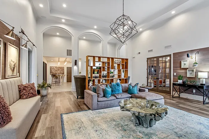 Elegant clubhouse with high ceilings, modern decor, and a luxurious open floor plan, featuring a spacious seating area and a stylish glass coffee table.