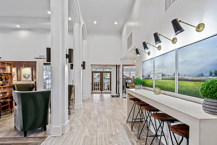 Elegant and inviting clubhouse interior featuring tall ceilings, stylish lighting, and cozy seating areas, perfect for relaxation.