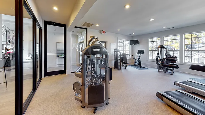 Bright and modern fitness center with state-of-the-art equipment, large windows, and sleek design.