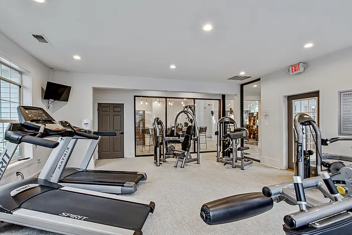Modern fitness center equipped with state-of-the-art treadmills and exercise machines, featuring a spacious and inviting design.