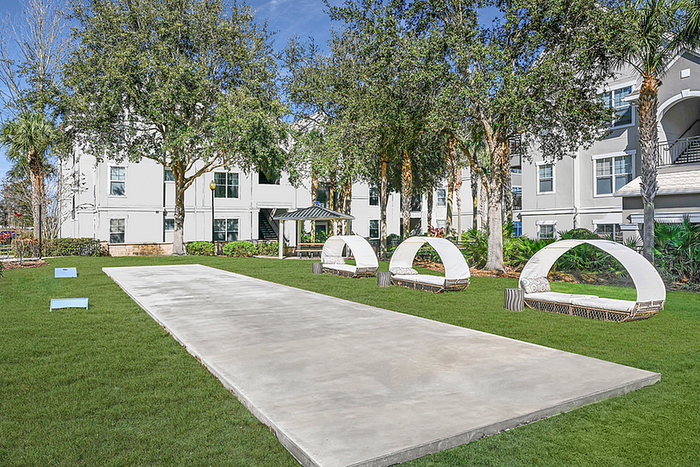 Inviting outdoor area with modern seating and lush greenery, perfect for relaxation and leisure activities in a vibrant apartment community.
