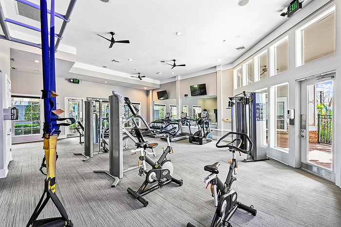 Bright and spacious fitness center featuring modern gym equipment and large windows for natural light.