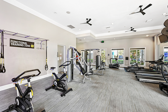 Modern fitness center with state-of-the-art equipment, featuring treadmills, exercise bikes, and a functional training zone for ultimate workouts.