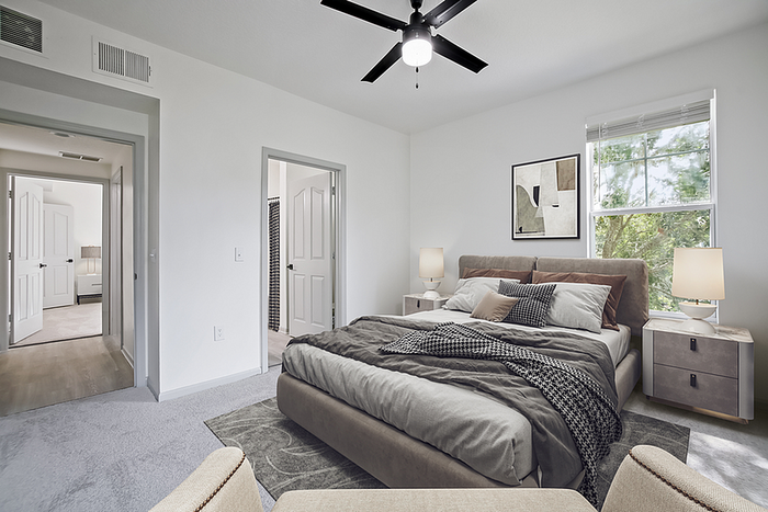 Bright and inviting bedroom with modern decor, plush bed, and large window offering serene views, ideal for a cozy and relaxing atmosphere.