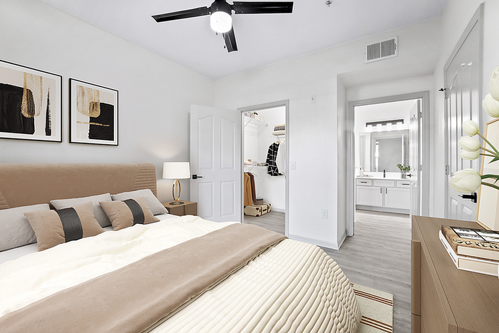 Elegant bedroom with modern decor, plush bedding, and convenient walk-in closet leading to a sleek en-suite bathroom.