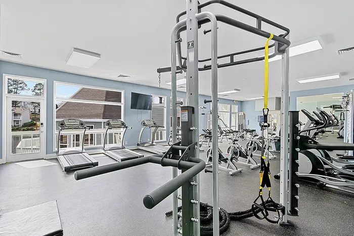 Bright and modern fitness center featuring state-of-the-art equipment, large windows, and an inviting atmosphere.