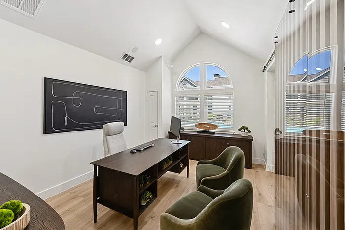 Elegant leasing office with high ceilings, large arched windows, and stylish furniture creating a bright and welcoming workspace.