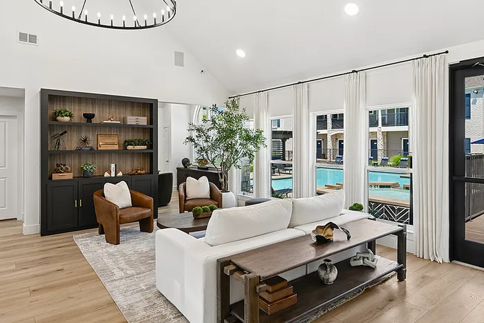 Inviting clubhouse with elegant decor, large windows offering serene pool views, and abundant natural light.
