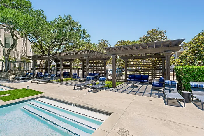 Luxurious poolside area with stylish pergolas, comfortable lounge chairs, and vibrant greenery, perfect for relaxation and social gatherings.