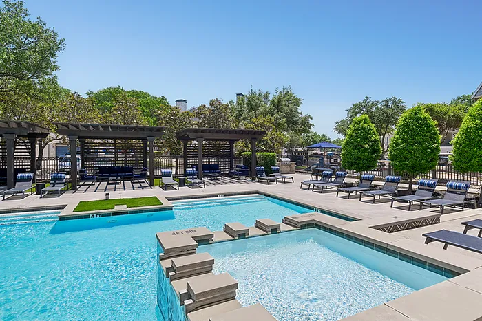 Luxurious pool area with stylish pergolas and plenty of sun loungers, perfect for relaxation in a serene setting.