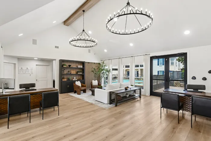 Modern leasing office with elegant lighting, chic seating areas, and a bright, open atmosphere overlooking a pool view.