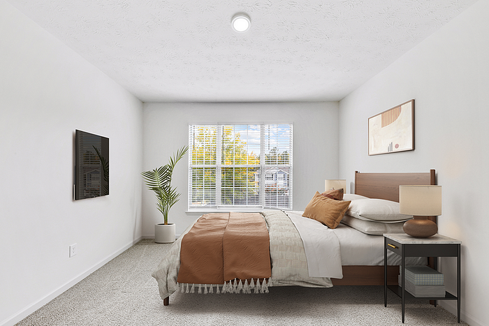 Bright and inviting bedroom featuring a large window, cozy bed with stylish linens, and modern decor for ultimate relaxation.
