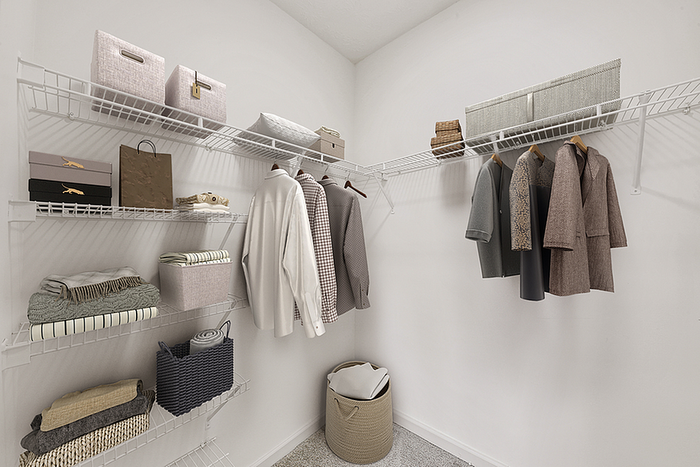 Modern walk-in closet elegantly organized with clothing racks, storage bins, and a variety of stylish garments.
